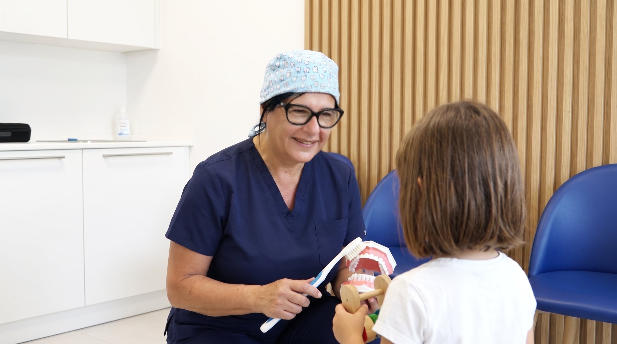 Paura del dentista a Lucca: la Dott.ssa Barbara Berti parla con una paziente prima della visita, poltrona dritta e strumenti lontani